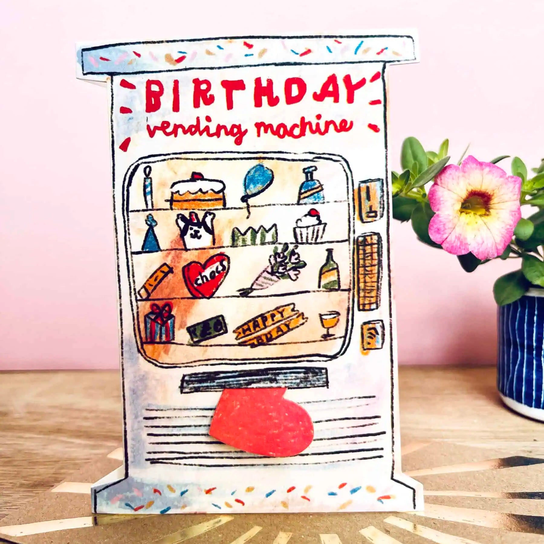 Greetings card featuring a birthday vending machine with a pink background