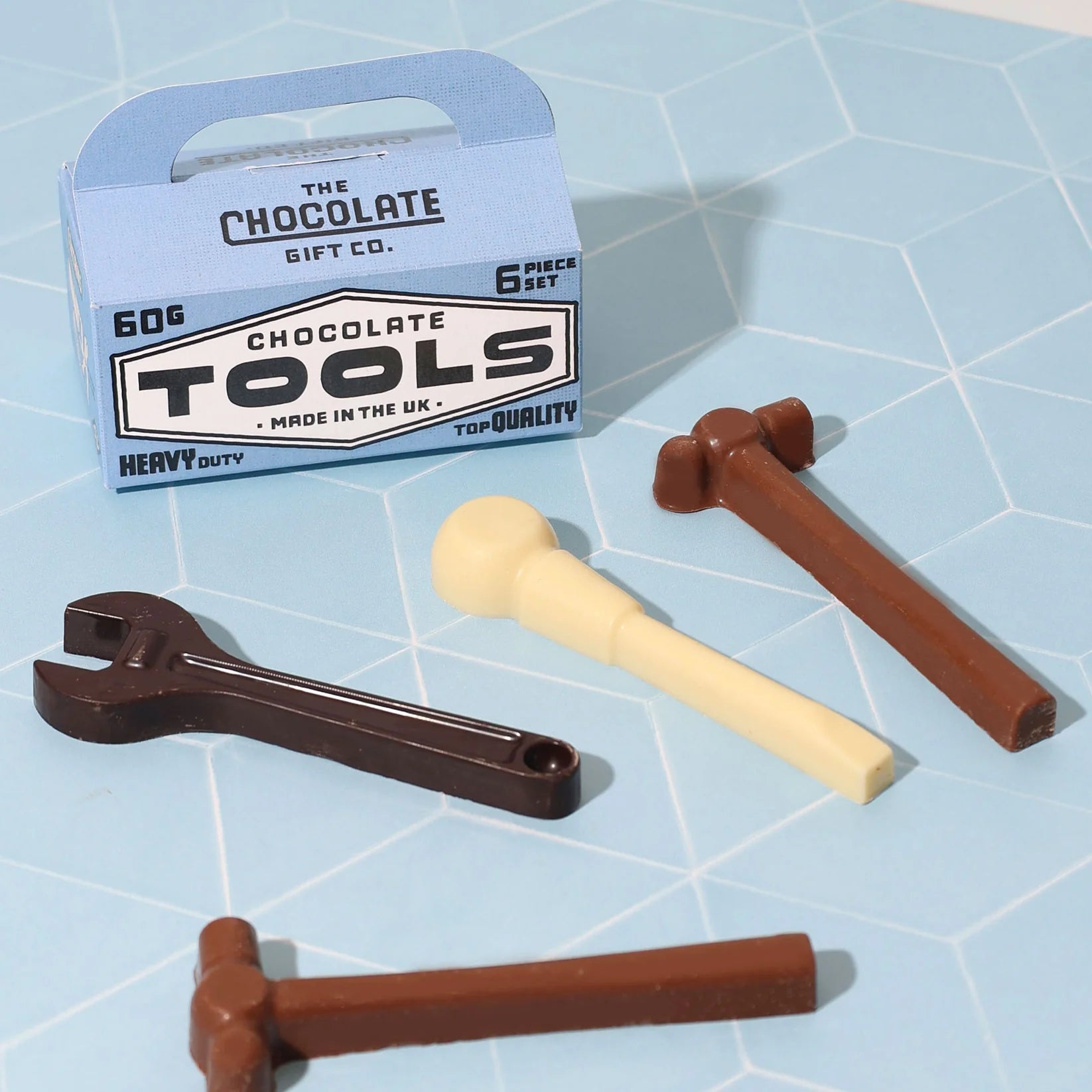 Tool shaped chocolates arranged on a blue background with a blue card toolbox