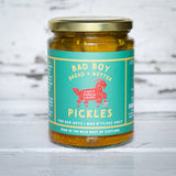 Jar of pickles with a green label on a wooden surface